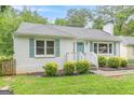 Quaint one-story home with white brick, light blue shutters, and verdant landscaping at 489 Radar Dr, Hapeville, GA 30354