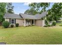 Beautiful home exterior with lush lawn, front porch and rocking chairs at 200 Pine Tree Ln, Mcdonough, GA 30252