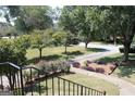 View of the beautifully landscaped front yard with mature trees, flower beds, and a sidewalk at 9342 Carillon Ct, Jonesboro, GA 30236