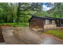 View of a garage with stone accents and a basketball hoop, set beside a charming home with a welcoming front porch at 69 Trace Ct, Stockbridge, GA 30281