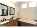 Elegant bathroom featuring a double vanity, soaking tub, and natural light from the window at 155 Glenwood Ln, Fayetteville, GA 30215