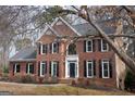 Traditional brick home with a well-manicured lawn and mature trees creating a welcoming curb appeal at 155 Glenwood Ln, Fayetteville, GA 30215