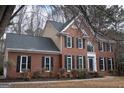 Classic brick two-story home with black shutters and mature trees set on a well-maintained lawn at 155 Glenwood Ln, Fayetteville, GA 30215