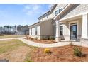 Inviting front porch with stone accents and a well-kept lawn leading to the home's entrance at 813 Dobby Way # 95, Mcdonough, GA 30252
