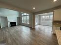 Open-concept living room with a fireplace, large windows, and hardwood floors at 817 Dobby Way # 96, Mcdonough, GA 30252