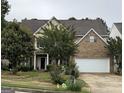 Charming two-story home with a brick facade and attached two-car garage at 12402 Muir Field Ct, Fayetteville, GA 30215
