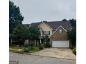 Charming two-story home with a brick facade and attached two-car garage at 12402 Muir Field Ct, Fayetteville, GA 30215