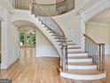 Elegant foyer featuring a curved staircase, hardwood floors, and detailed trim work at 6205 Arnall Nw Ct, Acworth, GA 30101