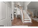 Inviting foyer featuring hardwood floors, staircase, and a view into the dining area at 1504 Oglethorpe Dr, Suwanee, GA 30024