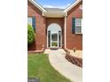 Close-up of a brick home's entry, showing a decorated front door, manicured landscape and garden gnomes at 1112 Haver Ct, Mcdonough, GA 30252