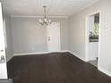 Spacious living room with hardwood floors, a decorative chandelier, and a view of the kitchen at 1876 Sw Sandtown Sw Rd, Atlanta, GA 30311