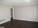 Neutral living room featuring dark hardwood floors, a textured ceiling, and a well-lit space at 1876 Sw Sandtown Sw Rd, Atlanta, GA 30311