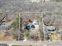 Aerial view showcasing the 1.27-acre property with mature trees, house, outbuilding, and surrounding landscape at 175 Laney Ct, Mcdonough, GA 30252