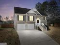 Two-story home featuring a two-car garage and stairway to front door at dusk at 8870 Dornoch Cir, Winston, GA 30187