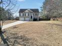 Two-story home featuring a two-car garage and stairway to front door on a sunny day at 8870 Dornoch Cir, Winston, GA 30187