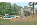 Backyard boasts large swimming pool, mature trees, and beautiful landscaping at 104 Hidden Springs Ln, Peachtree City, GA 30269