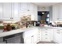 Close-up of updated kitchen featuring white cabinets and a farmhouse sink at 402 Stonebrooke Dr, Auburn, GA 30011