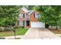 Charming brick home with a well-maintained lawn, two-car garage, and mature trees offering shade at 2009 Parador Aly, Mcdonough, GA 30253