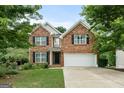 Inviting brick home with a manicured front lawn, black shutters, and an attached two-car garage at 2009 Parador Aly, Mcdonough, GA 30253