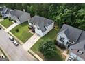 Aerial view of a suburban home with a two-car garage, green lawn and mature trees in a residential area at 3205 Anneewakee Falls Pkwy, Douglasville, GA 30135