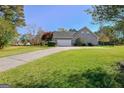 View of home showing driveway to attached garage and well-maintained lawn at 100 Clydesdale Ct, Tyrone, GA 30290