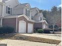 Exterior shot of multi-Gathering units with brick and siding, showcasing the attached garages and landscaping at 106 Ne Ellis Dr # 106, Conyers, GA 30012