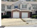 A view of the townhome's facade, showcasing the garage, neutral siding, and 'For Rent' sign at 106 Ne Ellis Dr # 106, Conyers, GA 30012