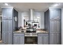 Kitchen features gray cabinets, granite countertops, stainless steel appliances, and a stylish range hood at 1379 Branchwood Dr, Snellville, GA 30078