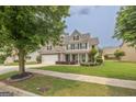 Inviting two-story home featuring a well-kept lawn and traditional design elements at 3338 Gardenside Walk, Loganville, GA 30052