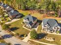 Aerial view of a suburban neighborhood showcasing well-maintained lawns and beautiful homes surrounded by lush greenery at 6857 Louis Dr, Locust Grove, GA 30248