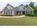 Beautiful home with stone and siding, complemented by lush landscaping and a welcoming front porch at 319 Beaconsfield Dr, Sharpsburg, GA 30277