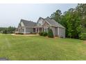 Spacious home on a large lot, showcasing a combination of stone and siding exterior details at 319 Beaconsfield Dr, Sharpsburg, GA 30277