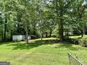 Expansive, green backyard surrounded by lush trees offering shade and privacy at 3683 Miller St, Lithia Springs, GA 30122