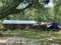 Charming single-story home with a brick facade, metal roof, and a spacious, green lawn and mature trees at 3683 Miller St, Lithia Springs, GA 30122