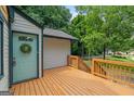 Cozy deck with a welcoming blue door and a wreath, surrounded by lush greenery and a charming neighborhood view at 243 Howell Sw Ter, Atlanta, GA 30331