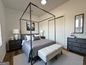 Modern bedroom with a four-poster bed, neutral colors, and ample natural light at 2873 Shoals Hill Ct, Dacula, GA 30019