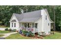 Side view of a white home with a charming front porch and a second-story deck with an outside stairway at 10 Stagg Trce, Social Circle, GA 30025