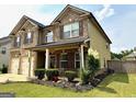 Inviting two-story home with manicured landscaping, a two-car garage, and charming front porch at 558 Hideaway Dr, Jonesboro, GA 30238
