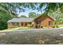 Inviting brick home with a well-manicured lawn, covered front porch, and a charming landscape at 1000 Turner Church Rd, Mcdonough, GA 30252