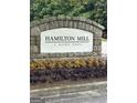 Stone entrance sign to Hamilton Mill featuring manicured landscaping and colorful flowerbeds at 3381 Walkers Ridge Rd, Dacula, GA 30019