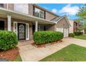 Close-up of front door with brick exterior, manicured bushes and a two-car garage at 907 Brisley Cir, Hampton, GA 30228