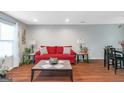Inviting living room with hardwood floors, a red sofa, and natural light at 3823 Rock Hollow Ct, Conley, GA 30288