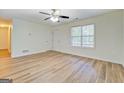 Bright living room featuring laminate floors, ceiling fan, and a window at 4547 Atha Cir, Loganville, GA 30052