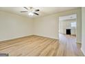 Bright living room with laminate floors, ceiling fan, and open layout into the kitchen area at 4547 Atha Cir, Loganville, GA 30052