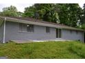 Rear view of the house with a brick exterior, featuring a patio and a view of the green backyard at 6286 Saddlewood Dr, Lithonia, GA 30058