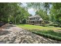 Charming two-story home with a welcoming front porch and a well-manicured lawn at 10875 Shagbark Trl, Roswell, GA 30075