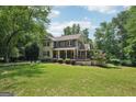 Charming two-story home with a welcoming front porch and a well-manicured lawn at 10875 Shagbark Trl, Roswell, GA 30075