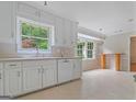 Bright kitchen features white cabinets, a window, and a view of the outdoors at 1977 Kensington High Sw St, Lilburn, GA 30047