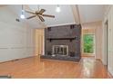 Spacious living room showcasing a brick fireplace, hardwood floors and a ceiling fan at 1977 Kensington High Sw St, Lilburn, GA 30047