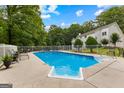 Backyard pool with fencing, lounge chairs, and well-maintained greenery, perfect for outdoor relaxation at 607 Lees Mill Rd, Fayetteville, GA 30214
